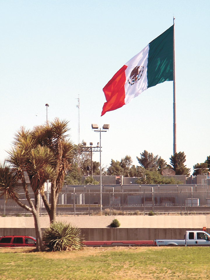 The Mexican flag beyond the border fence near the El Paso-Juarez bridge crossing—West Texas, between El Paso and Fort Hancock